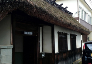 風情ある建物の雰囲気にマッチした、カッティングシートを貼った木の看板