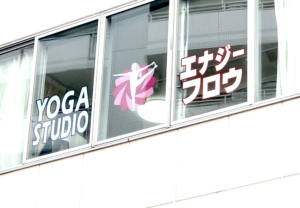 窓に貼られたヨガポーズのカッティングステッカー。デザインと色づかいがポイント