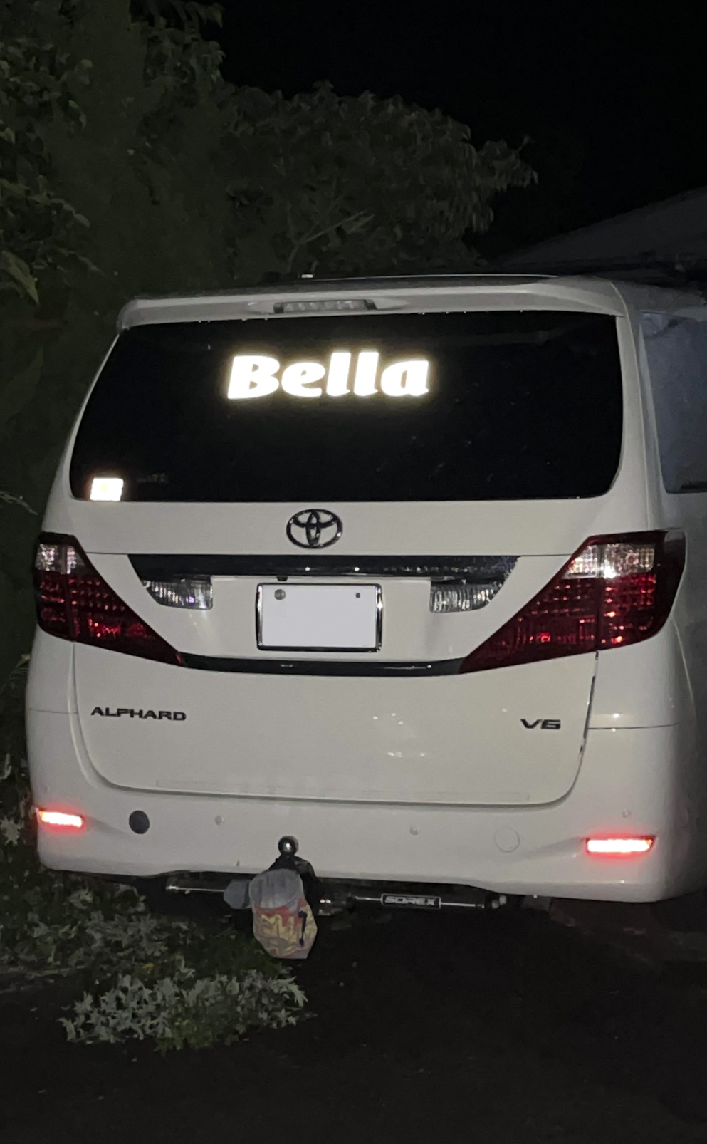 暗闇で光に反射している車のリアガラスに貼られた反射カッティングシート