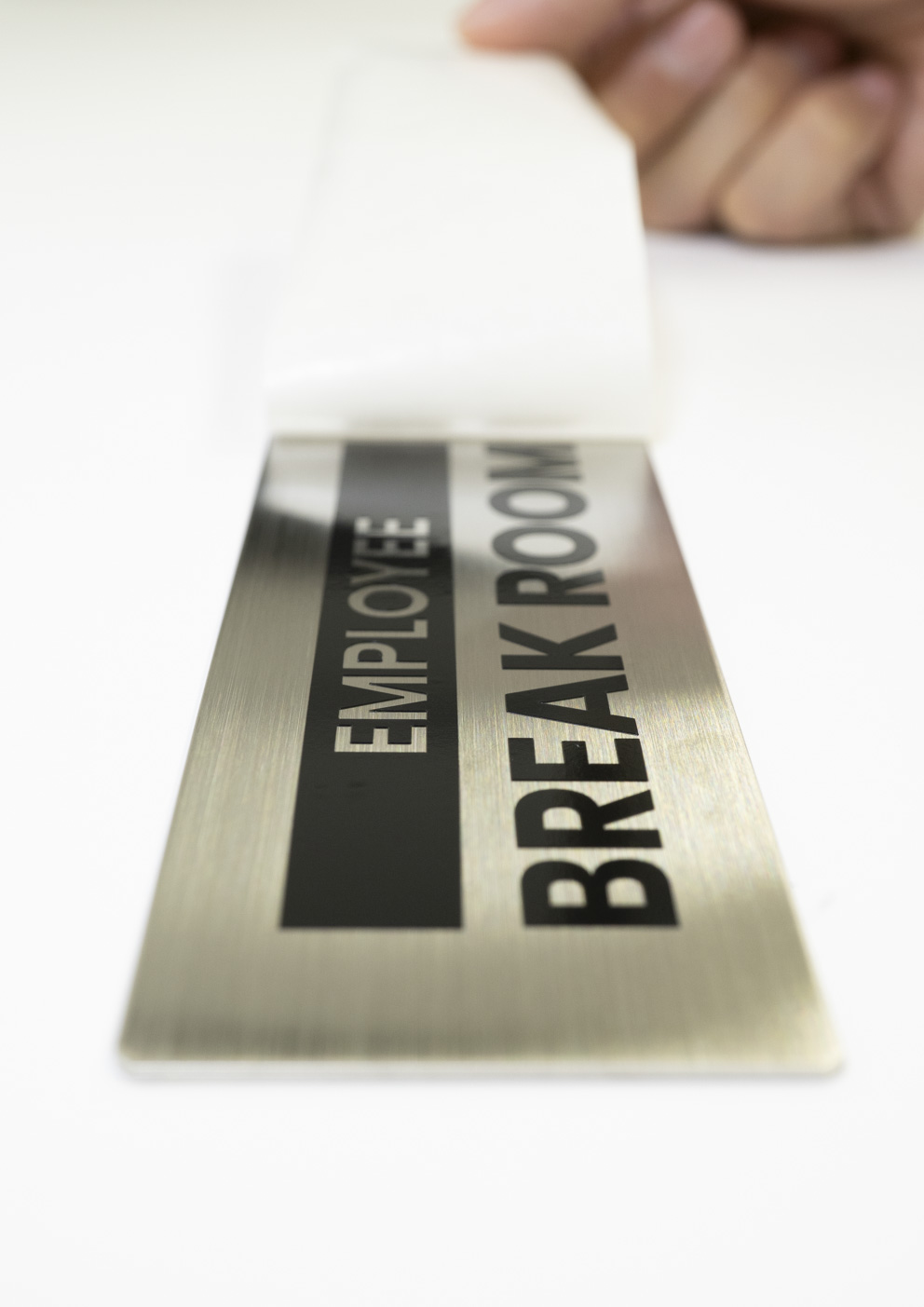 銘板にカッティングシートを貼っている写真