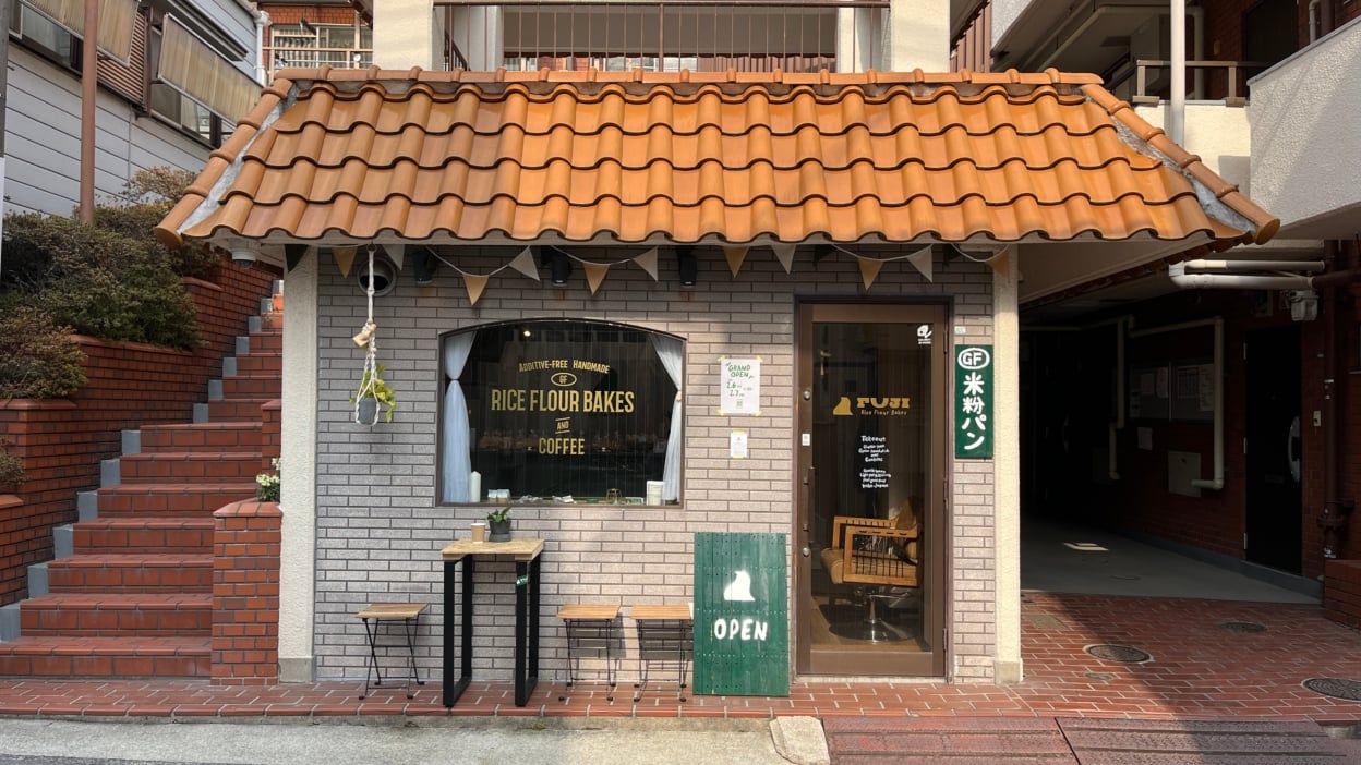 窓ガラスに貼られたカッティングシートを店舗が全て入るように写した写真