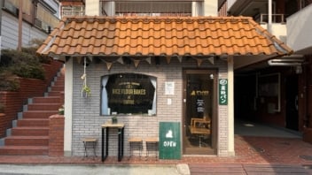 窓ガラスに貼られたカッティングシートを店舗が全て入るように写した写真